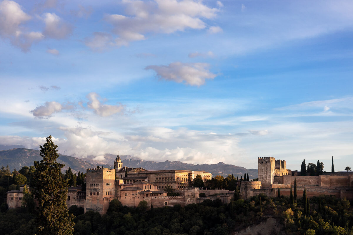 Le château de Grenade en Andalousie est entouré d'arbres et de montagnes.