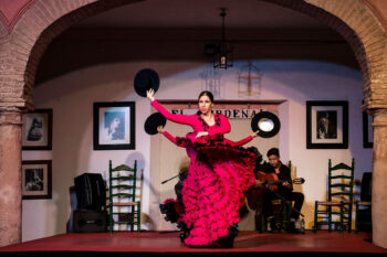 Une femme en robe rouge exécute une danse flamenco andalouse.