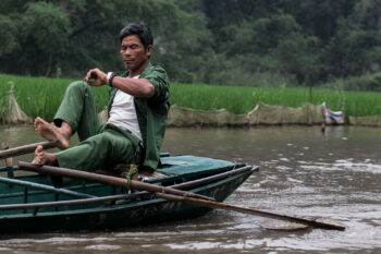 Un homme assis dans un bateau sur une rivière au Vietnam.