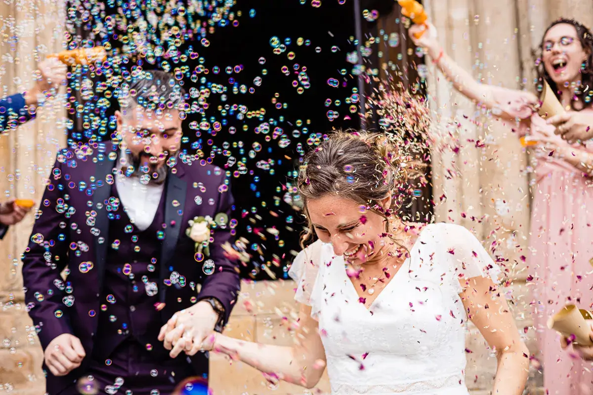 Les mariés sortants de la cathédrale sous une tonne de bulles.