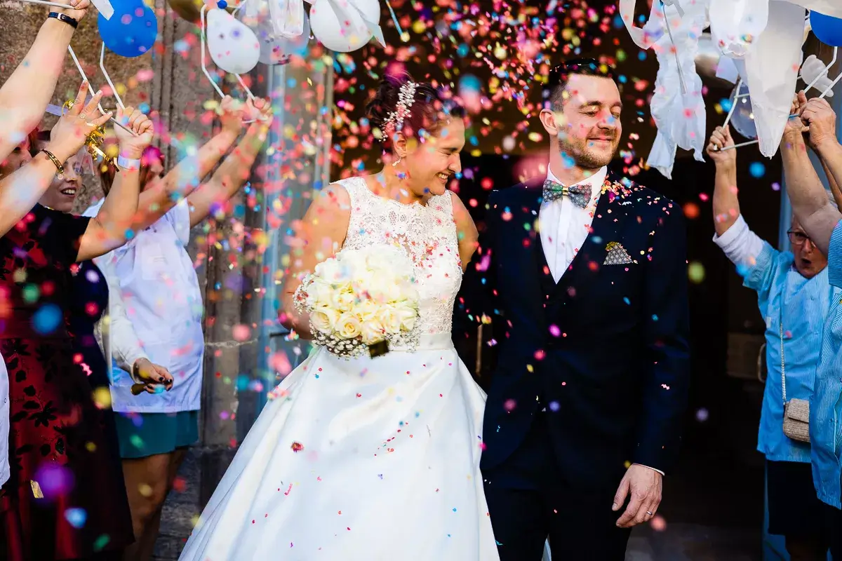 Les mariés sortants de la cérémonie devant les invités.