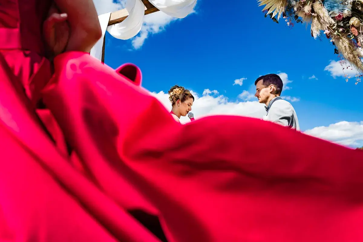 Une robe rouge volant devant les mariés.