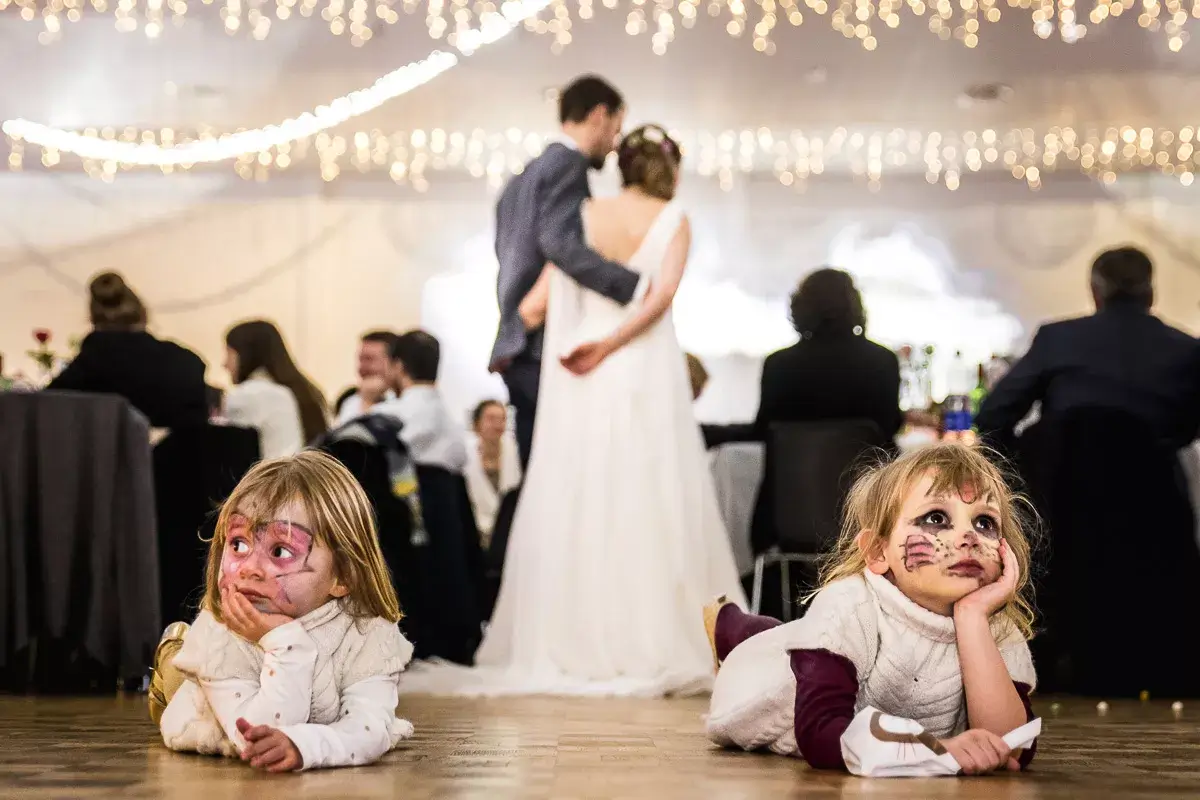 Deux petites filles couchés à plat ventre sur le sol, devant les mariés