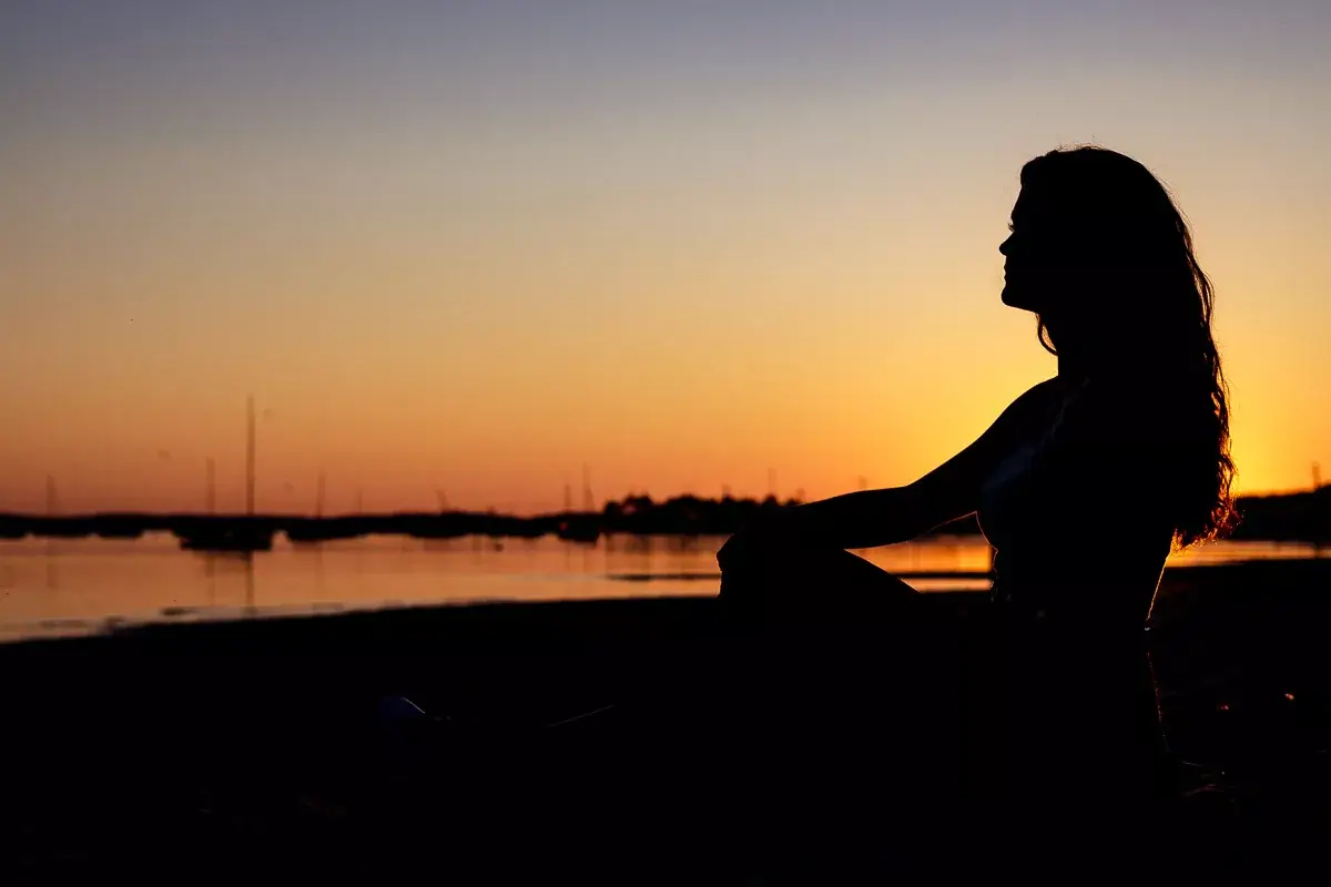 L'ombre d'une jolie fille devant la mer et le couché du soleil.