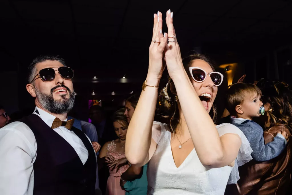 Les mariés qui s'ammusent avec des lunettes de soleil, durant la soirée de mariage.
