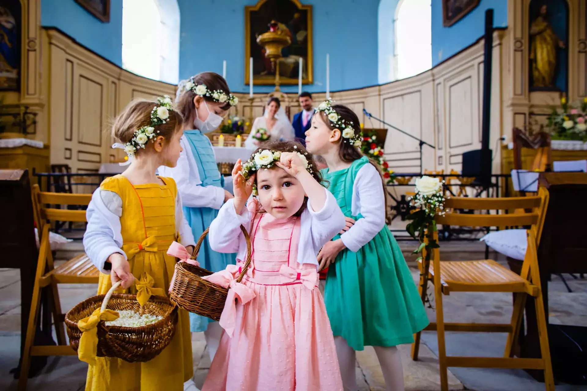 Les enfants enfilants leurs couronnes de fleurs à l'église.