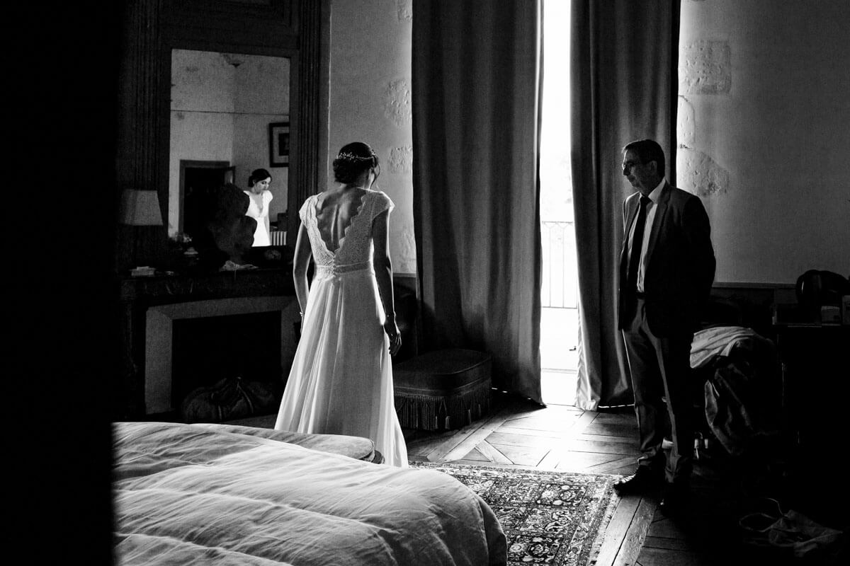 Des préparatifs de mariage d'un couple debout devant une fenêtre.