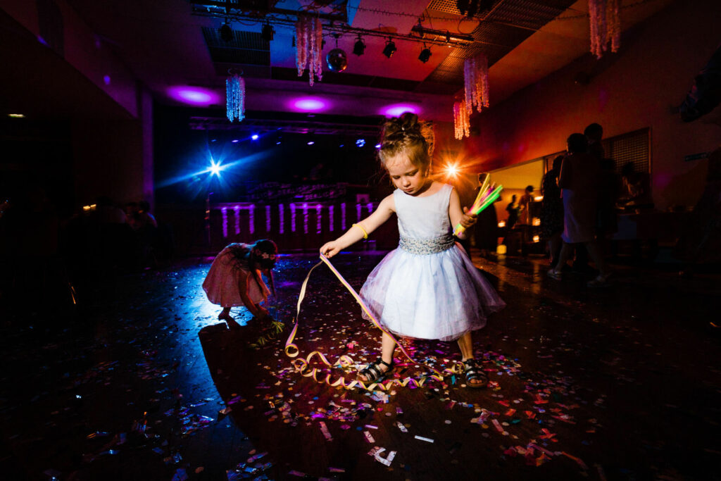 Une fillette d'honneur se promène sur une piste de danse de mariage vide