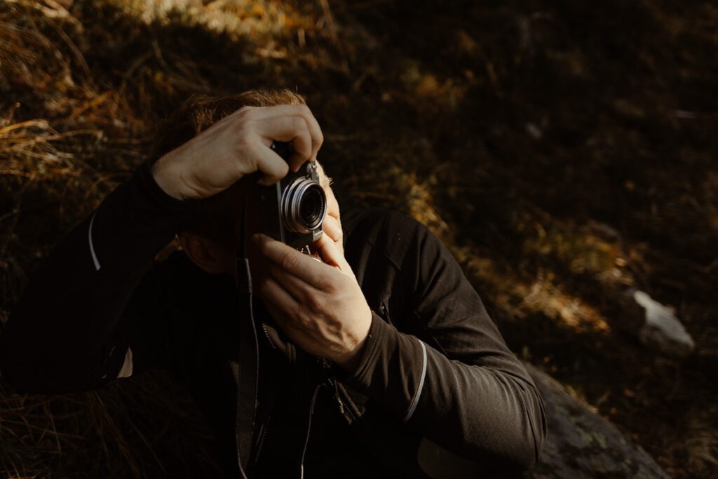 A man taking a photo with a camera at Brorrick Mountain.