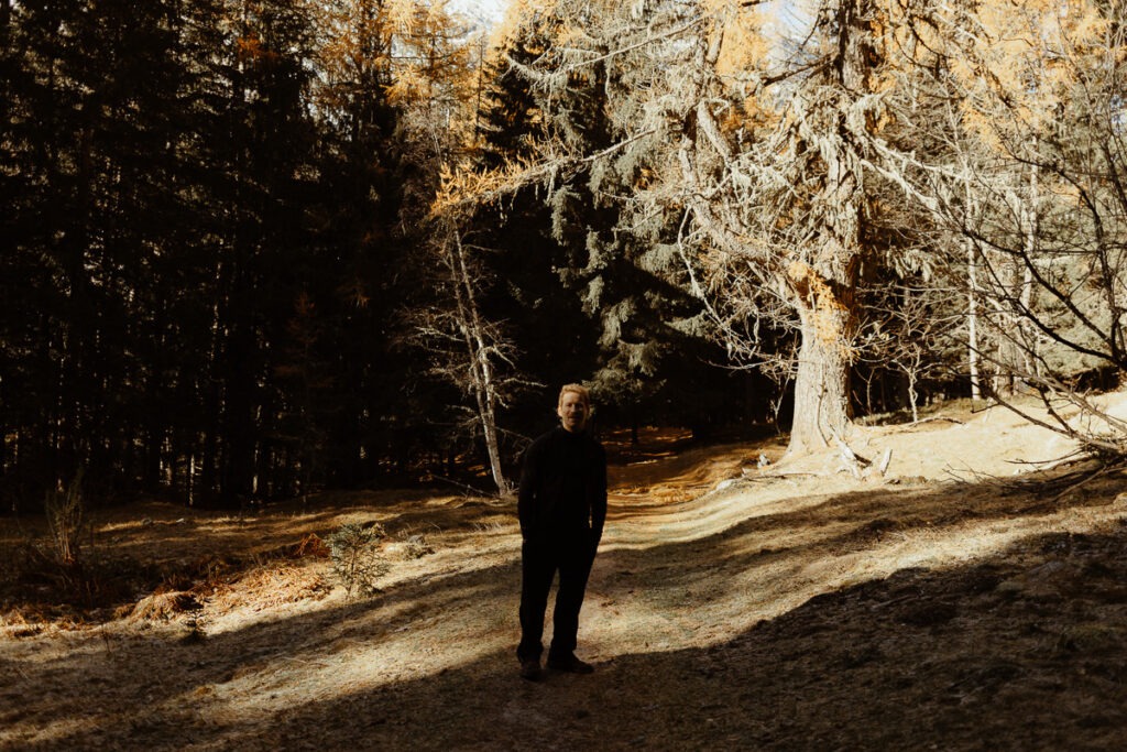 A man standing on a path in the woods near Mount Brorrick.