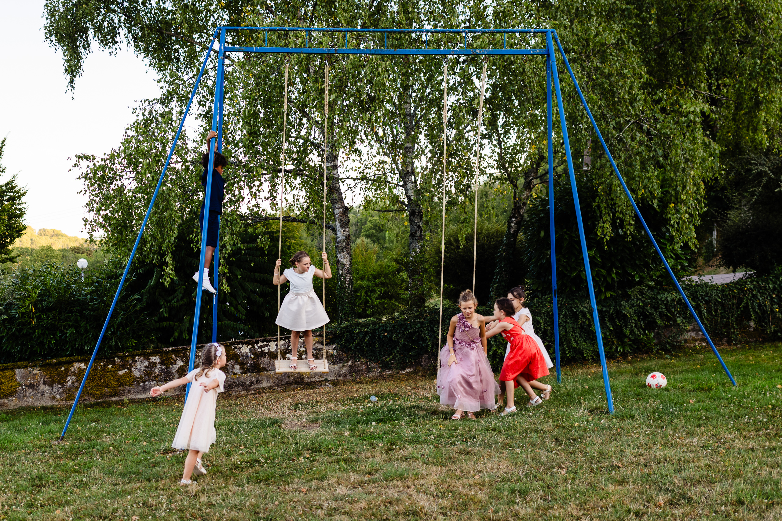 Cinq enfants en tenues de cérémonie sur la balançoire bleue, Ferme Sainte-Anne de Langres
