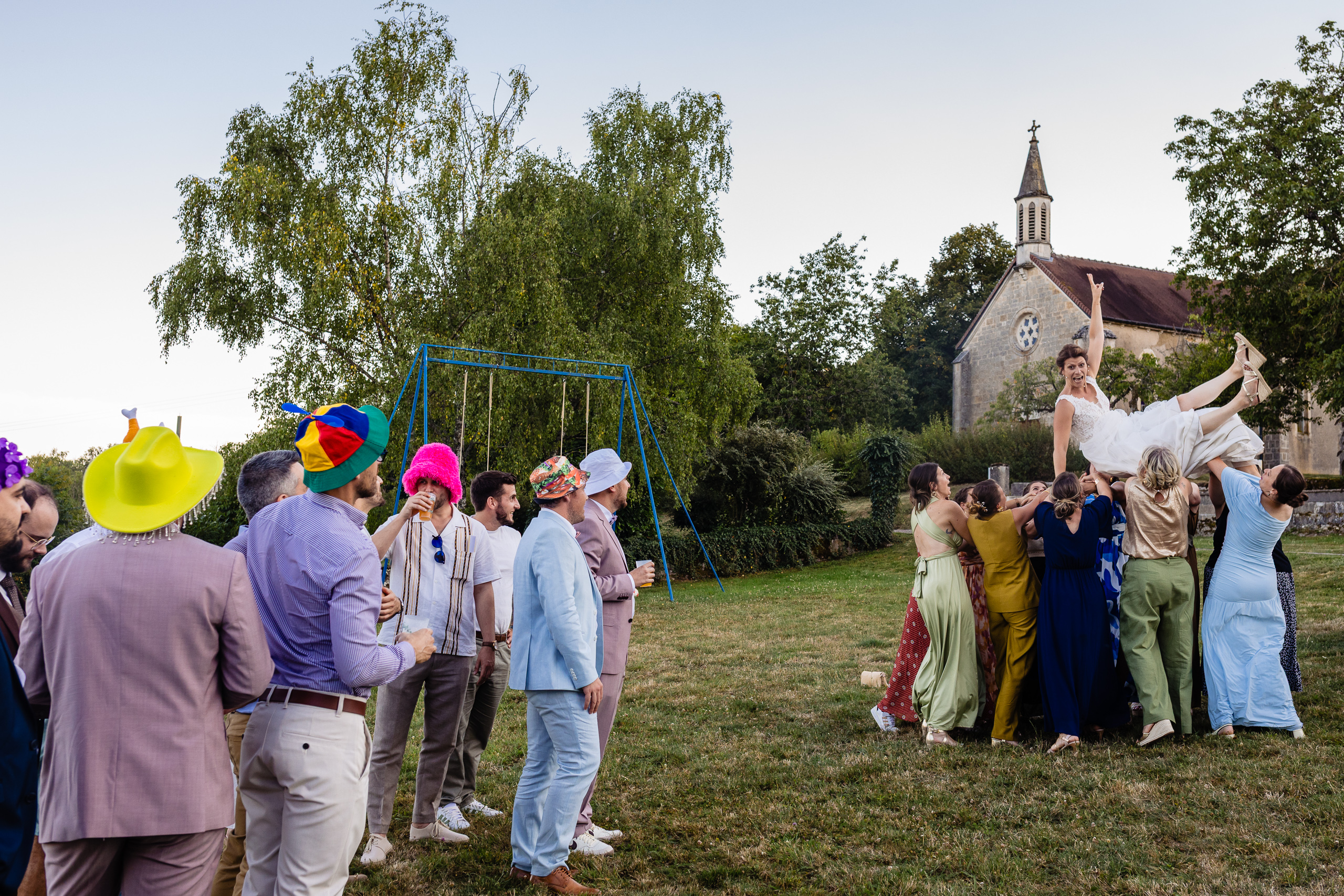 Amélie soulevée dans les airs par des amis, invités en chapeaux colorés, Ferme Sainte-Anne Langres