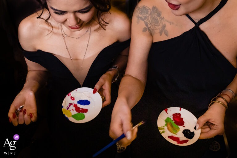 Deux invitées tiennent leurs palettes pendant la peinture collective de la soirée.